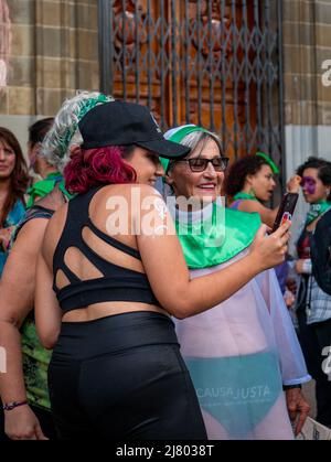 Medellin, Antioquia, Kolumbien - März 8 2022: Eine ältere Frau, die als Nonne gekleidet und in Grün gekleidet ist, posiert mit einer jungen rothaarigen Frau für ein Foto-Befo Stockfoto