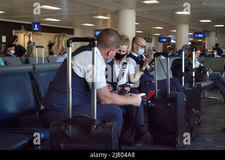 Flugbegleiter von American Airlines verwenden ihre Smartphones, während sie im Terminal des Phoenix Sky Harbor International Airport in Phoenix, Arizona, sitzen. Stockfoto