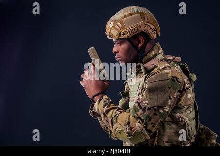 amerikanischer Mann im Tarnanzug mit einer Pistole Stockfoto