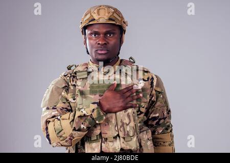 afroamerikanischer Soldat mit gefalteten Armen im weißen Studio Stockfoto