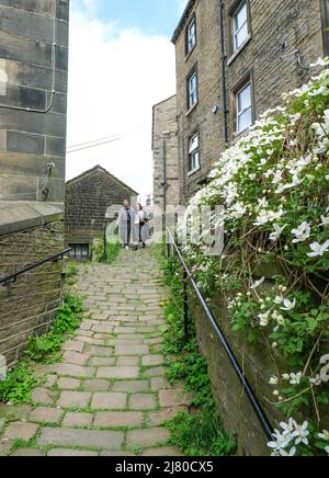 Steinhütten und gewundene gepflasterte Wege über der West-yorkshire-Stadt Holmfirth. Stockfoto