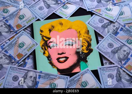 Geschossen Sage Blue Marilyn Kunstwerk auf einem Bildschirm von ipad umgeben von Dollar-Banknoten. Ein Porträt von Marilyn Monroe von Andy Warhol. Stafford, Großbritannien Stockfoto