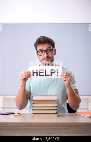 Junge Schüler, die sich auf Prüfungen im Klassenzimmer vorbereiten Stockfoto