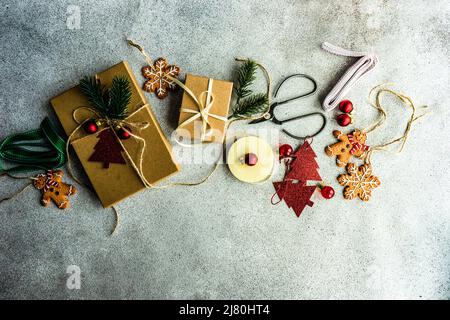 Deckenansicht von Weihnachtsgeschenkschachteln, Dekorationen und Lebkuchenornamenten auf einem Tisch Stockfoto