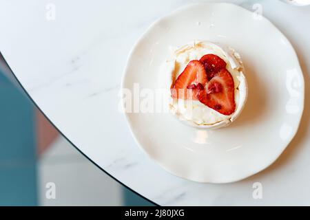 Ansicht eines Tellers mit einem Baiser-Kuchen mit frischen Erdbeeren von oben Stockfoto