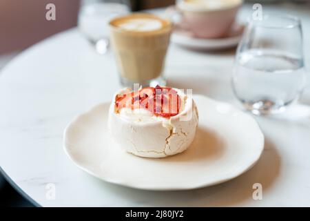 Kaffee, Wasser und Baiser-Kuchen mit frischen Erdbeeren Stockfoto