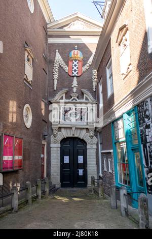 Amsterdamer Museumseingang mit Amsterdamer Stadtwappen in einer engen Gasse zwischen Ziegelgebäuden in Amsterdam, Niederlande Stockfoto