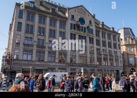 Touristenmenge vor Madame Tussauds Wachsmuseum und Peek & Cloppenburg an einem sonnigen Tag auf dem Dam Square im Zentrum von Amsterdam, Niederlande Stockfoto