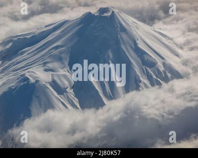 Luftaufnahme des Mt Taranaki Peak durch die Wolken, Nordinsel, Neuseeland Stockfoto