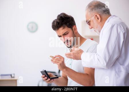 Junger Patient mit Hörproblemen, der einen Arzt besucht, einen HNO-Arzt Stockfoto