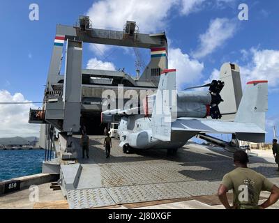 APRA HARBOUR, GUAM (28. April 2022) – vertraglich vereinbarte Seemänner an Bord von Cape Horn laden 1. Marine Aircraft Wing MV-22 Ospreys von Marine Medium Tiltrotor Squadron 363 (VMM-363) von der Marine Corps Base Hawaii auf das Military Sealift Command Schiff am 28. April in Apra Harbour, Guam. 1. MAW nahm kürzlich an der Balikatan 22 Teil. Der Luftflügel trainiert kontinuierlich mit gemeinsamen Kräften, Partnern und Verbündeten in herausfordernden und realistischen Umgebungen und Szenarien. „Obwohl wir die Ausstattung für dieses Flugzeug haben, konnten wir erstmals die V-22s auf Kap Horn laden“, sagte Capt. Benjamin Day Stockfoto