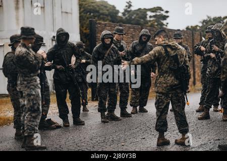 US-Marineinfanteristen mit Marine Air Support Squadron (MASS) 2 führen während der Vagabond Jungle Field Übung 22-1 in Camp Hansen, Okinawa, Japan, 5. Mai 2022 einen Konvoi-Brief durch. MASS-2 führte diese Übung durch, um die Bodenkampf-Fähigkeiten, die Logistik und das Training des Direct Air Support Center (DASC) zu verbessern, während es in der Indo-Pazifik-Region operierte. (USA Marine Corps Foto von PFC. Justin J. Marty) Stockfoto