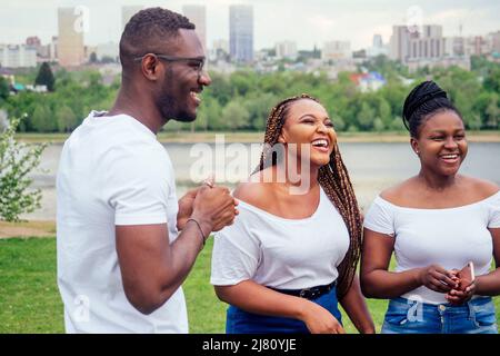 Freundschaft junge Millennial multiethnischen afro Zöpfe Dreadlocks Freunde sprechen verbringen Wochenende zusammen Herbst bewölkten Abend Stockfoto
