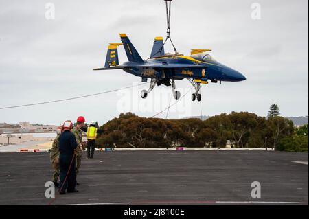 220503-N-TL932-1037 PAZIFISCHER OZEAN (3. Mai 2022) Matrosen und Zivilpersonal transportieren eine an den Blue Angels befestigte F/A-18 Super Hornet auf das Flugdeck des Nimitz-Klasse-Flugzeugträgers USS Carl Vinson (CVN 70), 3. Mai. Vinson befindet sich derzeit in seinem Heimathafen San Diego auf dem Pierside. (USA Navy Foto von Mass Communication Specialist Seaman Joshua Sapien) Stockfoto