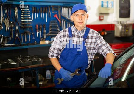 Professioneller Automechaniker posiert in der Werkstatt Stockfoto