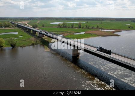 Seehausen, Deutschland. 29. April 2022. Blick auf die Brücke der Bundesstraße 189 über die Elbe in Richtung Seehausen. Daneben verläuft die Baustelle für die Elbbrücke entlang der Strecke der Autobahn 14. Für den Neubau der Autobahn 14 zwischen der Anschlussstelle Seehausen-Nord (Sachsen-Anhalt) und Wittenberge (Brandenburg) beginnen heute die Arbeiten für die neue, staatlich verbindende Elbbrücke. Zunächst beginnen südlich der Elbe die Arbeiten an den Fundamenten für die Pfeiler der Uferbrücke und des Abutments (Foto aufgenommen mit einer Drohne). Quelle: Peter Gercke/dpa/Alamy Live News Stockfoto