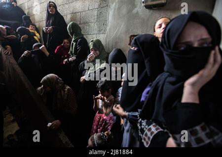 Gaza, Palästina. 11.. Mai 2022. Palästinensische Frauen und Verwandte des 28-jährigen Mahmoud Aram trauern während seines Begräbnisses in Khan Yunis im südlichen Gazastreifen. Aram wurde bei dem Versuch, in der Nähe einer von Israel kontrollierten Sicherheitsbarriere im nördlichen Westjordanland zu überqueren, getötet, wie die IDF mitteilte, da er 2019 zur Behandlung in das Westjordanland ziehen durfte. (Foto von Yousef Masoud/SOPA Images/Sipa USA) Quelle: SIPA USA/Alamy Live News Stockfoto