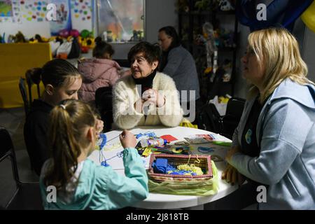 Saporischschschja, Ukraine. 11.. Mai 2022. Zwei junge Mädchen nehmen in einem der Flüchtlingszentren in Zaporizhzhia, Ukraine, an Kunsthandwerk Teil. Nach der Ankunft helfen Freiwillige kleinen Kindern mit Kunst, während sie als Flüchtlinge verarbeitet werden. Kredit: SOPA Images Limited/Alamy Live Nachrichten Stockfoto