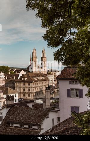 Blick auf das historische Stadtzentrum von Zürich mit der berühmten Grossmünster-Kirche aus dem Lindenhof-Park, Zürich, Schweiz Stockfoto