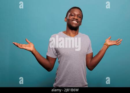 Unsichere Person, die Schultern aufsteigt und Verwirrung äußert, ich kenne keine Geste im Studio. Unsicherer Mann, der sich unentschlossen und ahnungslos über Antwort oder Lösung fühlt. Verwirrt. Stockfoto