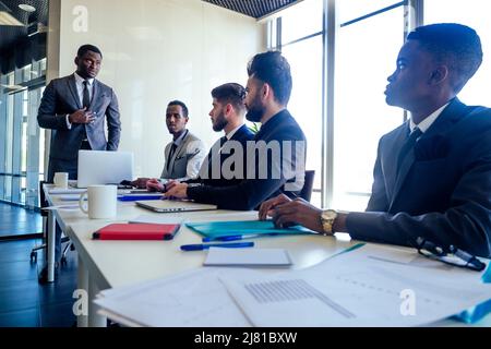 Chef afro Geschäftsleute im Gespräch mit arabischen Partnern Kollegen, multiethnischen Team im Büro mit Panoramafenster. Stockfoto