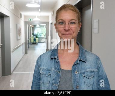 Hannover, Deutschland. 26. April 2022. Yvonne Sabovic-Dunsing, Leiterin der Spezialpflegestelle für Menschen mit Adipositas, steht im Korridor der Pflegestelle auf dem Gelände des Gesundheitsunternehmens Diakovere in Hannover. Das Angebot richtet sich an 30- bis 60-Jährige, die dauerhaft Gewicht verlieren und wieder mobil werden wollen. (To dpa: „Die versteckte Pandemie - rund 14 Millionen Menschen mit Adipositas“) Quelle: Mia Bucher/dpa/Alamy Live News Stockfoto