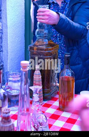 Mittelteil einer Frau mit einer großen Flasche Brandy Stockfoto