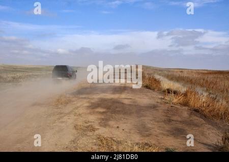 SUV-Automobil, das Staub auf unbefestigten Straßen im landwirtschaftlichen Bereich verursacht Stockfoto