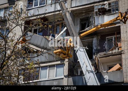 Charkiw, Ukraine. 6.. Mai 2022. Arbeiter entfernen Trümmer eines Wohngebäudes, das durch einen russischen Artilleriestreik im Gebiet Charkiw in der Ukraine getroffen wurde. Während Russland seine Truppen neu versorgt und die Offensive auf den östlichen Teil der Ukraine konzentriert hat, sind Charkow und die umliegenden Gebiete in der Ukraine nun ständig von russischen Bombardierungen und Luftangriffen bedroht. (Bild: © Alex Chan/SOPA Images via ZUMA Press Wire) Stockfoto