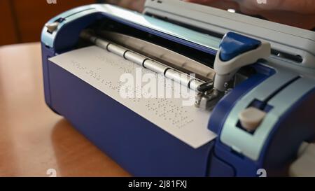 Blinder Mann mit Brailleschrift-Schreibmaschine. Stockfoto