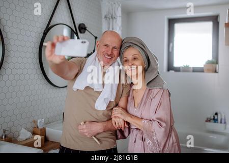 Verliebtes Seniorenpaar im Badezimmer, Selfie, morgendliches Routinekonzept. Stockfoto