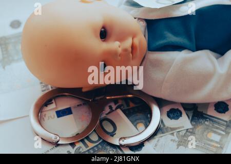 Baby Puppe liegt mit Handschellen. Kinderkriminalität Konzept. Hochwertige Fotos Stockfoto