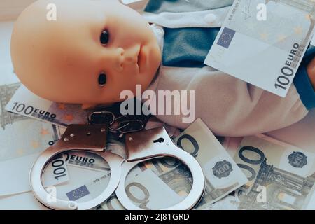 Baby Puppe liegt mit Handschellen. Kinderkriminalität Konzept. Hochwertige Fotos Stockfoto