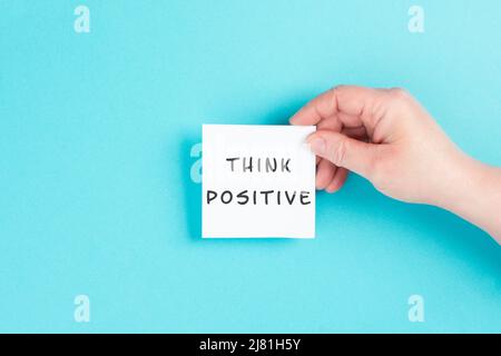 Die Worte „positiv denken“ stehen auf einem Papier, optimistische Denkweise, Coaching- und Motivationskonzept, Einstellung für den Erfolg Stockfoto