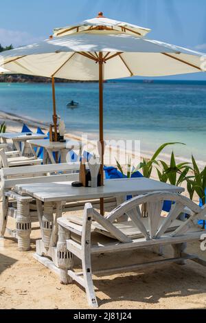 Holztisch und Stühle in leerem Strandcafé neben dem Meerwasser in Nahaufnahme. Insel Koh Phangan, Thailand Stockfoto