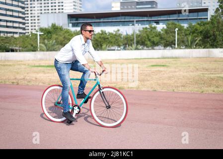 Junge Hipster Mann Reiten feste Ausrüstung Fahrrad auf Stadt Straße Stockfoto