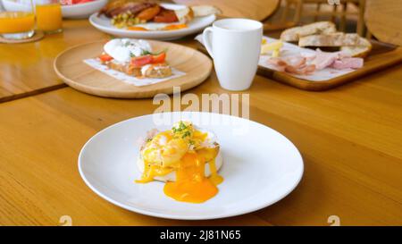 Ei benedict mit flüssigem Eigelb schneiden, englischer Muffin im Restaurant, Frühstück Stockfoto