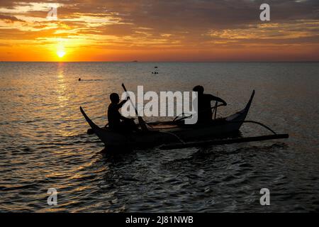 Puerto Galera, Philippinen - 2022. April: Sonnenuntergang am Strand von Puerto Galera am 26. April 2022 in Oriental Mindoro, Philippinen. Stockfoto