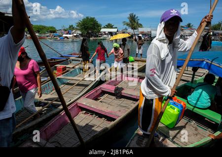 San Jose, Philippinen - 2022. Mai: Menschen, die am 3. Mai 2022 in Ockidental Mindoro den Pandurucan River mit dem Boot in der Nähe des San Jose Marktes überqueren. Stockfoto