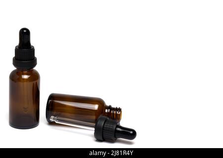 Nahaufnahme von zwei braunen Flaschen mit Pibette auf dem Deckel für die Verabreichung von Medikamenten auf weißem Hintergrund Stockfoto