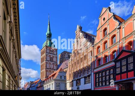 Giebel von denkmalgeschützten Gebäuden in der Badenstraße und Blick auf die Nikolaikirche, UNESCO-Weltkulturerbe der Hansestadt Stralsund, Deutschland. Stockfoto