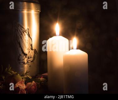 Metallurne mit Asche einer toten Person auf einer Beerdigung. Trauriger trauernder Moment am Ende eines Lebens. Letzter Abschied und Trauer Konzept. Stockfoto