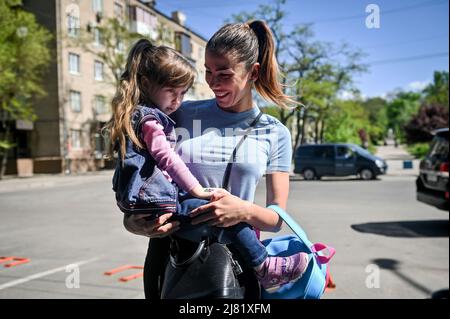 Saporischschschja, Ukraine. 10/05/2022, Stellvertretende Leiterin der regionalen Militärverwaltung Saporischschschja, Zlata Nekrasova, bleibt bei Alisa, 4, die während der jüngsten Evakuierung aus dem Asowstal-Stahlwerk, Saporischschschja, im Südosten der Ukraine, unbegleitet reiste. Das Mädchen und die Mutter, ein Gesundheitshelfer, die in einem der Azovstal-Bunker untergebracht waren, wurden von russischen Invasoren in einem Filterlager im sogenannten „DNR“ getrennt. Später brachte Alisas Onkel das Mädchen in die Westukraine, um ihre Großmutter aus Polen zu treffen. 10.Mai 2022. Foto von Dmytro Smolyenko/Ukrinform/ABACAPRESS.COM Stockfoto