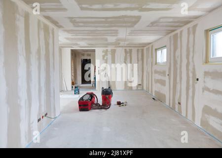 Leeres Wohnzimmer nach Spachtelarbeiten an Wänden und Decke in einem Neubau Stockfoto