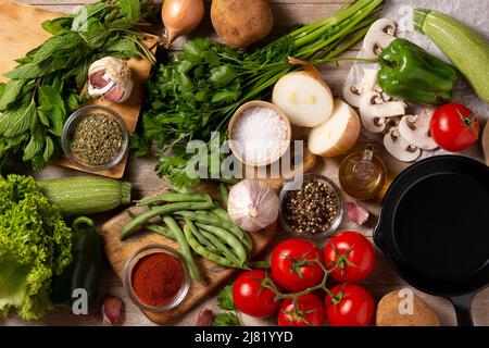 Sortiment an Gemüse, Kräutern und Gewürzen auf Holztisch Stockfoto
