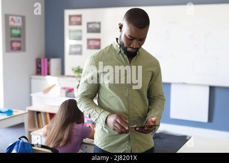 afroamerikanischer junger Lehrer mit digitalem Tablet im Klassenzimmer Stockfoto