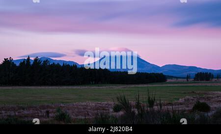 Wolken treiben über Mt Ngauruhoe bei Sonnenuntergang, North Island. Stockfoto