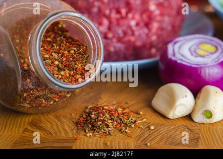 Gewürze mischen Knoblauchzwiebel und gehacktes Fleisch zum Kochen auf einem Holztisch. Speisen und Zutaten der Küche Stockfoto