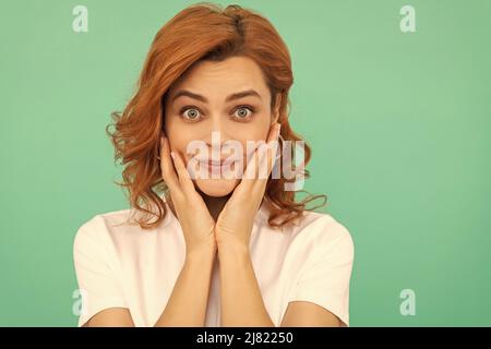 Erstaunt Rotschopf Mädchen mit perfekter Haut und lockiges Haar auf blauem Hintergrund, Porträt der Schönheit Stockfoto