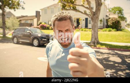 Glücklicher bärtiger Mann, der den Daumen nach oben zeigte, genehmigt Stockfoto